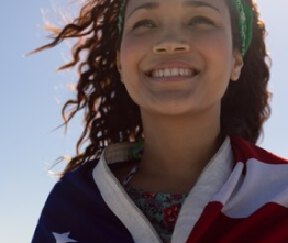 mujer sonriendo con bandera de USA